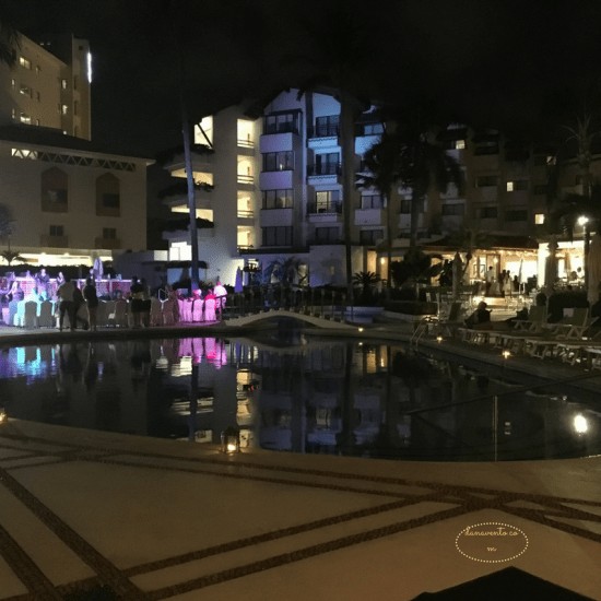 Buenaventura Grand Hotel at night with lights by pool 