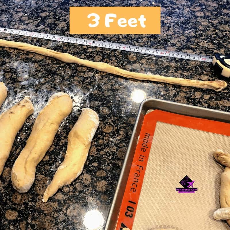 Cinnamon pretzels with icing on tray and dough on side in process 