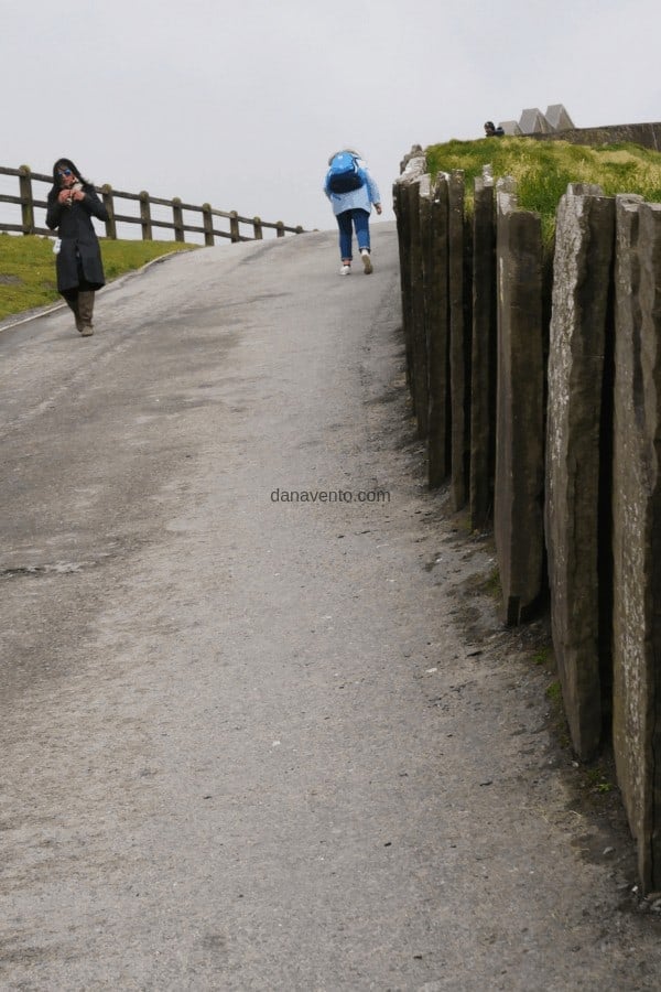 Woman climbing a steep hill path and walking