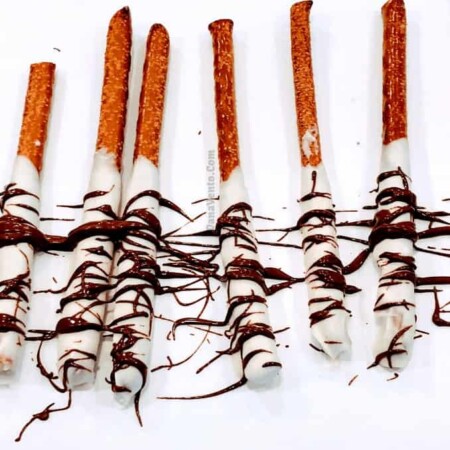 Easy Hand-Drizzled Chocolate Covered Pretzel Rodsm white chocolate, dark chocolate, mild chocolate, dipping, dunking, tall glass, video recipe, how to recipe, holiday recipe, chocolate covered pretzels, chocoatel covered, chocolate dipping, dipping in glass, video recipe, recipe video, Christmas recipe, Party Recipe, platters, foods, snacks, dessert, easy to make, easy to recreate, pretzel sticks, pretzel rods, striping, dries fast