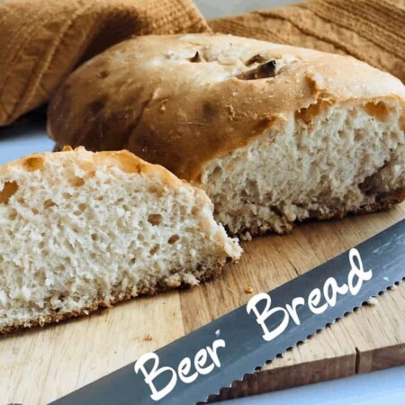 Beer bread sliced on board with serrated knife