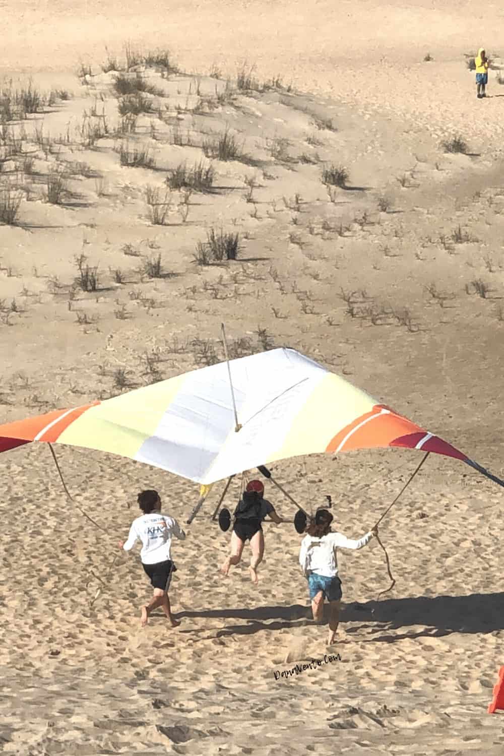 Hang Glider In Low of Dune with spectators 