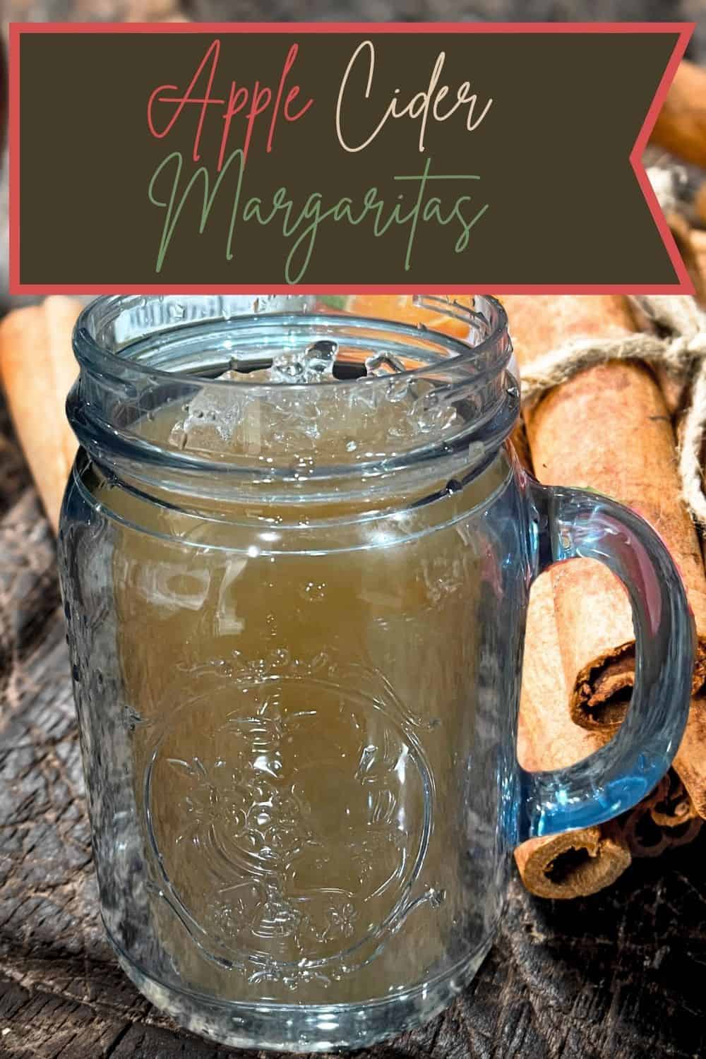 Apple Cider Margarita in glass with cinnamon sticks behind