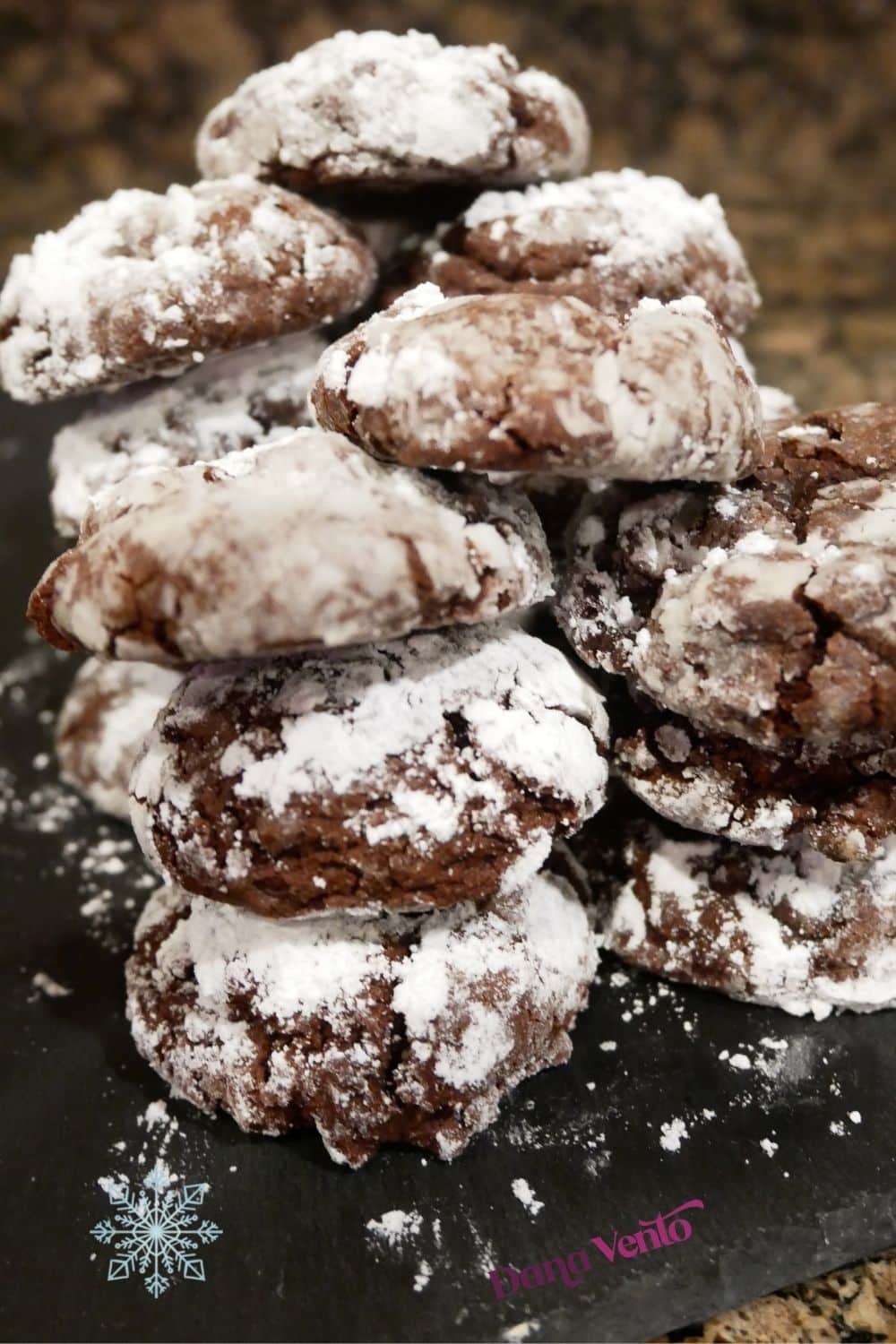 snow kissed chocolate crinkle cookies in small stacks