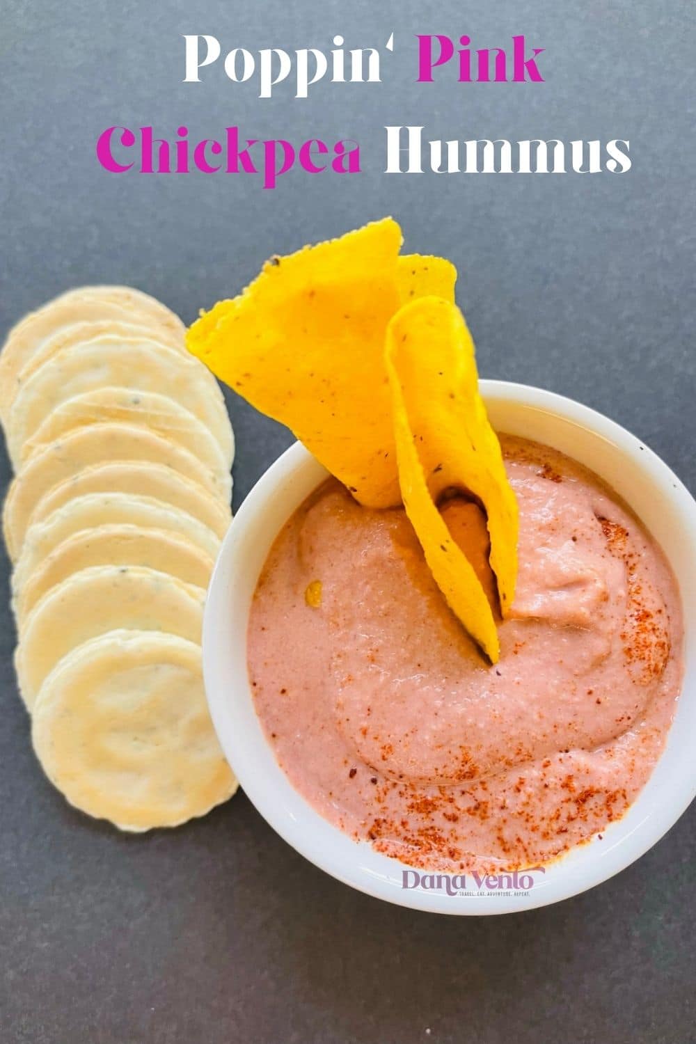 crackers and chips in hummus that is pink in a bowl
