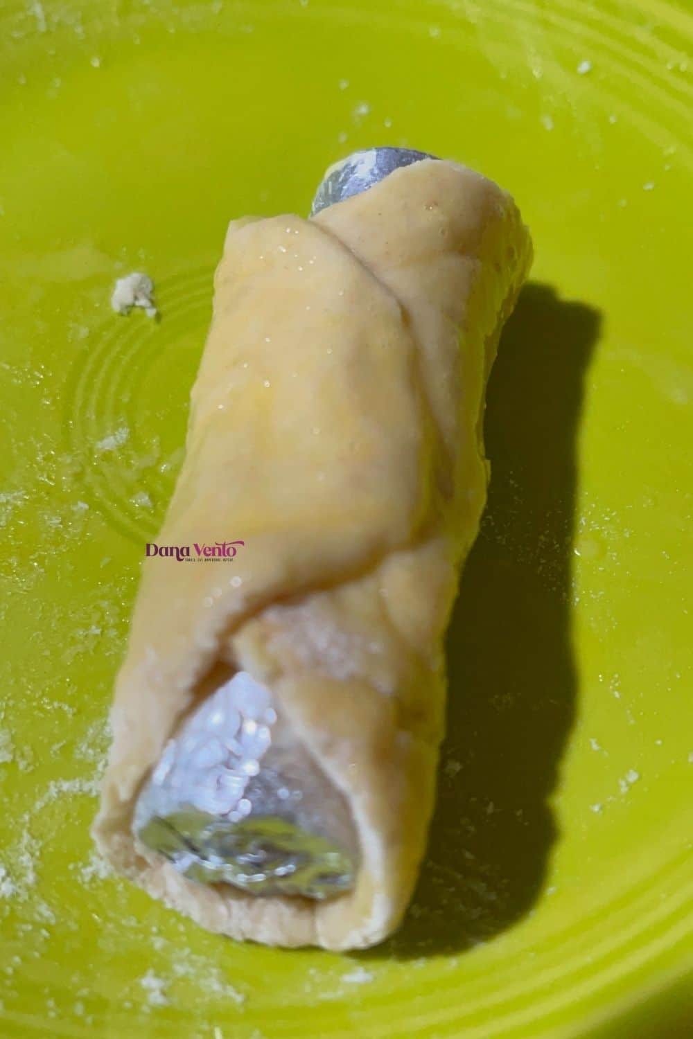 pastry wrapped around a cannoli pin on a plate to be air fried