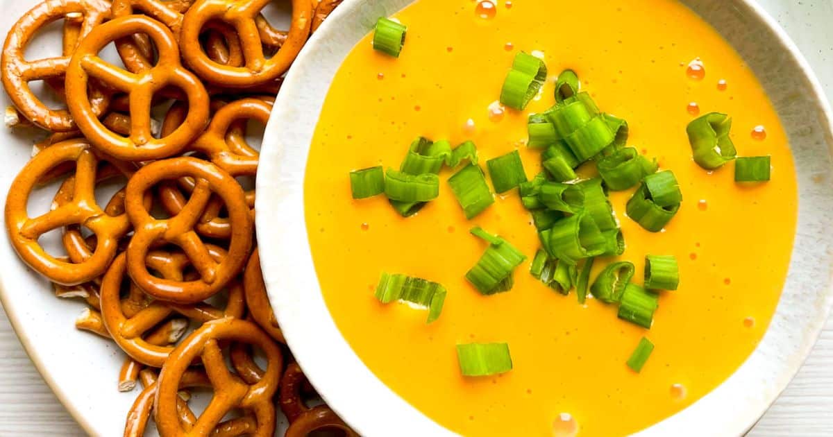 cheddar beer dip in a bowl with pretzels for dippable 