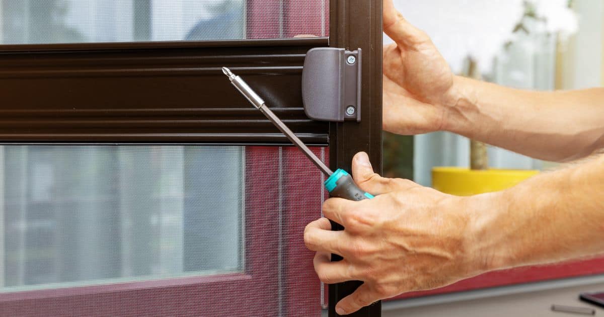 A person switching the storm door to a screen door