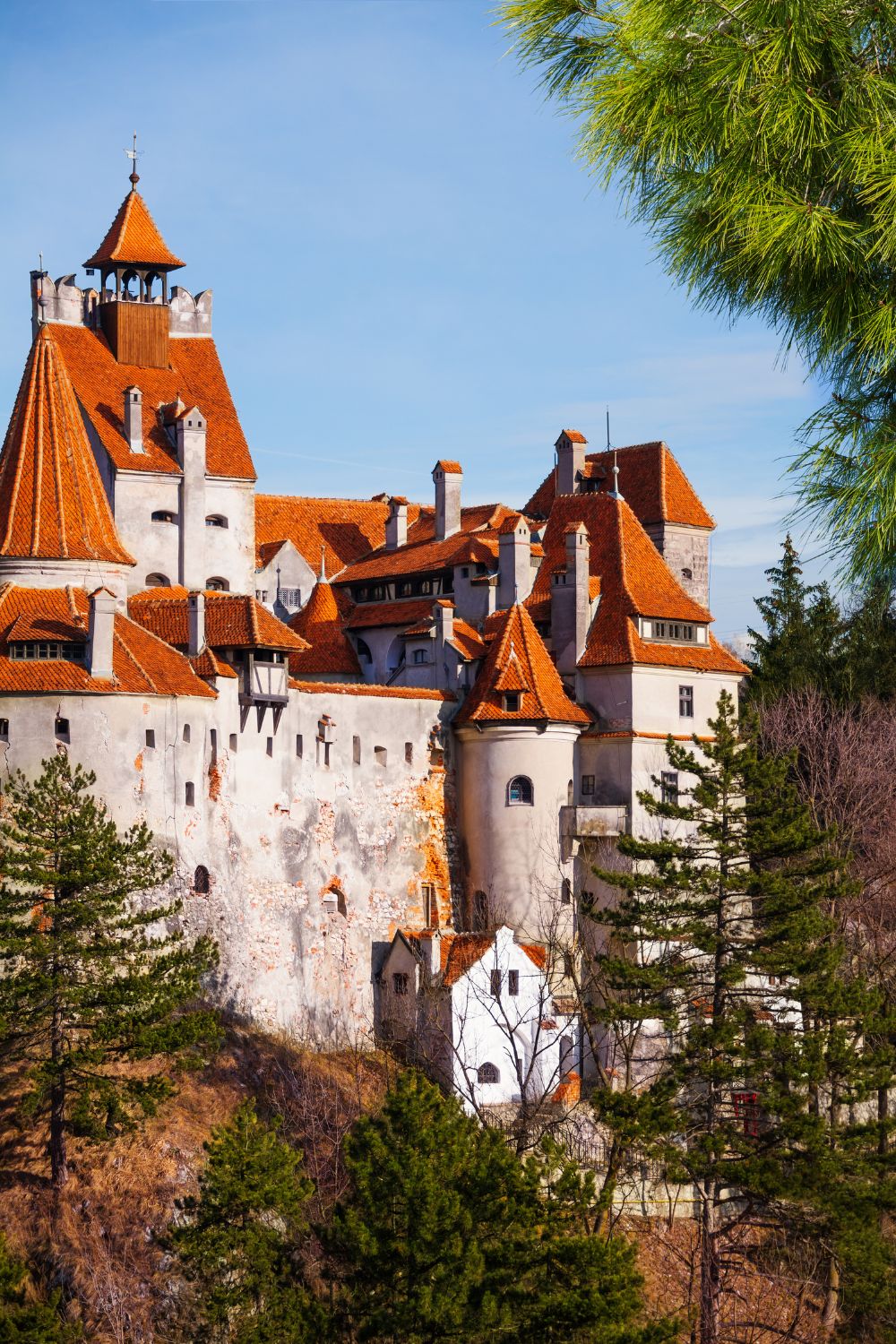The imposing Bran Castle set against a backdrop of autumn trees in Transylvania