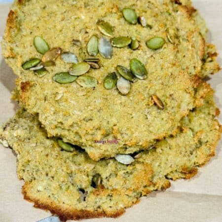 a healthy big avocado almond cookie with pepita seeds stacked on another one