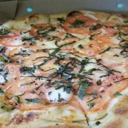 Freshly baked Margherita pizza with basil and mozzarella in a restaurant-style setting