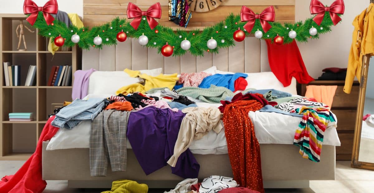 Decluttering Before the Holidays: Simple Ways to Stop Chaos 1 Messy bedroom with clothes piled on the bed, decorated with Christmas garland and ornaments, showing holiday clutter before organizing.
