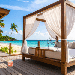 Luxury travel splurges beachfront villa with ocean view canopy bed and tropical cocktail setup.